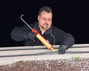 Tim Periard, Bird Doctor’s VP of operations, uses adhesive to secure  an electrified track.