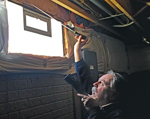 Dave Daniels of Speed Exterminating uses a long metal poker to investigate for evidence of termites around basement insulation.  Photo: Will Nepper