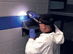 Termitech’s Steve Parke applies an aerosol in cracks and crevices in an  inmate cell.  Photo: Termitech