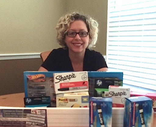 Kim Paolillo smiles appreciatively behind a table full of new supplies for her 3rd-grade classroom.