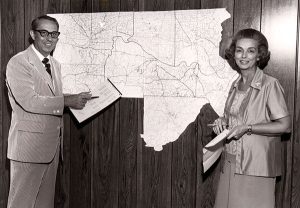 Jo and John Cook stand in front of a map showing their service area.  Photo: Cook's Pest Control