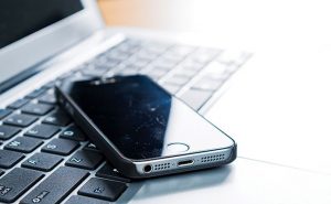 Phone sitting on computer. Photo: ©iStock.com/baona