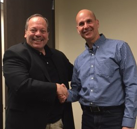 Anthony Merk, left, shakes hands with Michael Broder.