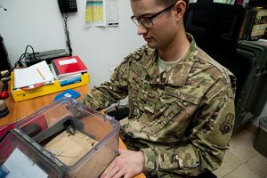 Argo holds a box containing a black fat-tailed scorpion and a keeled rock gecko Nov. 3 at an undisclosed location in Southwest Asia. (U.S. Air Force photo by Staff Sgt. William Banton)