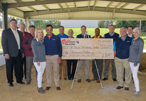 The Redd Pest Solutions leadership team stands under the facility's under-construction structure with the donation check. PHOTO: REDD PEST SOLUTIONS