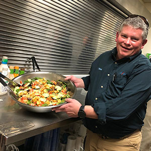 Michael Franks of Sprague Pest Control prepares salad for residents of the shelter. PHOTO: P.E.S.T. RELIEF INTERNATIONAL