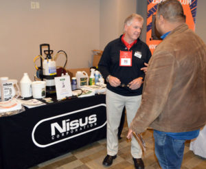 Harry Bryan, Area Sales Manager with Nisus Corp., talks with an attendee at the New York Pest Expo about Niban. PHOTO: MARTY WHITFORD