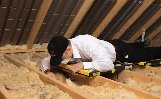 A PMP inspects the condition of existing attic insulation. PHOTO: PEST CONTROL INSULATION