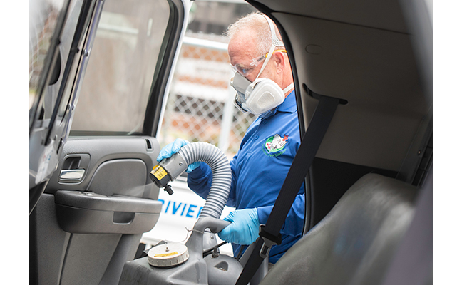 Nozzle Nolen Regional Branch Manager Scott Garver performs the DisMist service on a police cruiser. TRACEY BENSON PHOTOGRAPHY