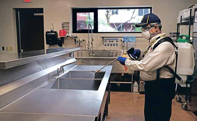 A Truly Nolen technician sanitizes a restaurant sink. PHOTO: GRANT HUNKER/TRULY NOLEN PEST CONTROL