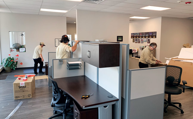 Setting up office cubicles at Schopen Pest Solutions this summer are, from left, Leeza Trainor, Jason Chaples and George Cochran. PHOTO: PETE SCHOPEN