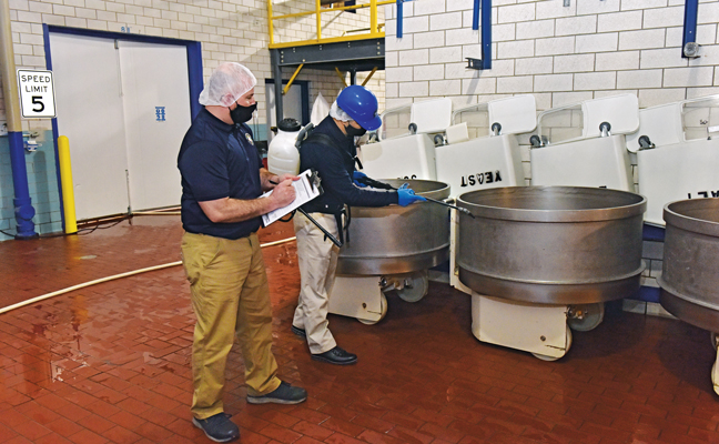 RK Environmental Services (RKE) Regional Operations Manager Chris Lazo, left, fills out a report as RKE Virucidal Program Service Specialist Johnny Echeverria begins to disinfect commercial mixing equipment at an account. PHOTO: FRED MILLER PHOTOGRAPHY