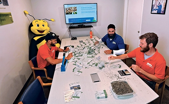 Stuffing Akita’s wildflower seed packets are, from left, Manny Mendez, inspector; Matt Leon, director of operations; and the author. PHOTO: AKITA PEST CONTROL