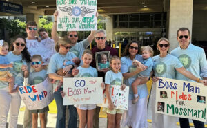 The author, center, holds a photo of Moss Pieratt while surrounded by family during the Brothers Bike 2025 tour. IMAGE: JENKS FAMILY