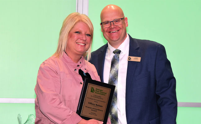 Tiffany Raines, Bug Busters, receives the Woman of Excellence award.