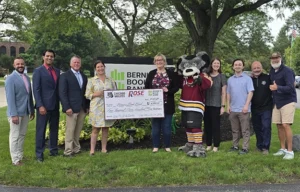 Group shot of Rose and Wolves leaders with check for Bernie's Book Bank.
