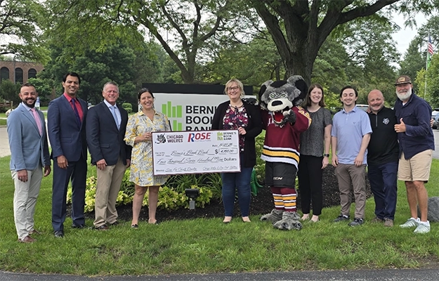 Group shot of Rose and Wolves leaders with check for Bernie's Book Bank.